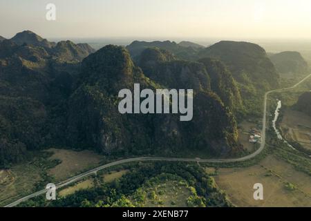 Strada che si snoda tra formazioni carsiche calcaree nella zona di Thakhek nel Laos; Thakhek, provincia di Khammouane, Laos Foto Stock