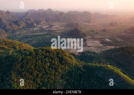 Caldo crepuscolo sui terreni agricoli e sulle formazioni carsiche calcaree nella zona di Thakhek nel Laos; Thakhek, provincia di Khammouane, Laos Foto Stock