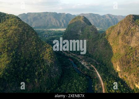 Strada nella valle tra formazioni carsiche calcaree nella zona di Thakhek nel Laos; Thakhek, provincia di Khammouane, Laos Foto Stock