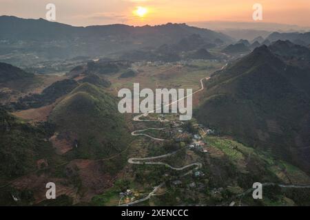 Strada che si snoda attraverso una campagna montuosa al tramonto a ha Giang, Vietnam; Dong ha, Quan Ba District, ha Giang, Vietnam Foto Stock