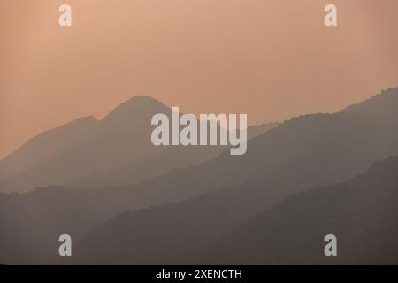 Strati di montagne sagomati al crepuscolo nebuloso; Ngoc Chien, Muong la District, Son la, Vietnam Foto Stock