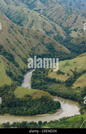 Fiume che si snoda attraverso un lussureggiante paesaggio montano con il remoto villaggio di Lembah Ollon Foto Stock
