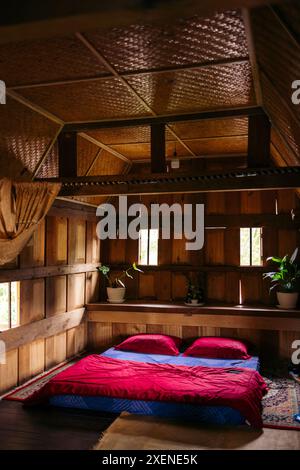 Interno di una casa tradizionale chiamata tongkonan, con un materasso sul pavimento di una camera da letto, a Sulawesi, Indonesia Foto Stock