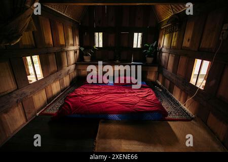 Interno di una casa tradizionale chiamata tongkonan, con un materasso sul pavimento di una camera da letto, a Sulawesi, Indonesia Foto Stock