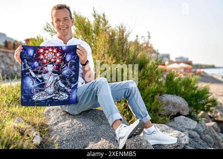 Turchia, Alanya - 14 aprile 2024. L'uomo tiene in mano il campo di gioco ampliato dell'antica squadra indiana Leela mentre è seduto nel parco naturale Foto Stock