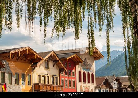 La città a tema bavarese di Leavenworth, Washington, presenta un'architettura in stile tedesco con uno sfondo di montagna, incorniciata da foglie verdi di un deciduo Foto Stock