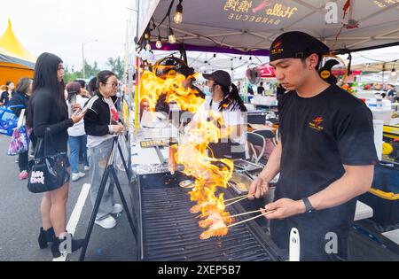 Markham, Canada. 28 giugno 2024. Un cuoco (davanti) griglierà le code di aragosta durante l'evento Taste of Asia 2024 a Markham, Canada, 28 giugno 2024. Il festival di tre giorni è iniziato qui venerdì. Crediti: Zou Zheng/Xinhua/Alamy Live News Foto Stock