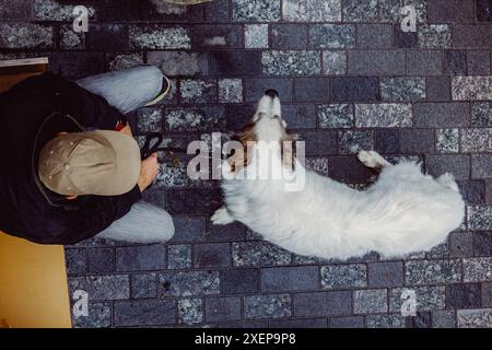 Un uomo siede con il suo cane Foto Stock