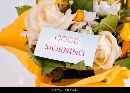 Parole BUONGIORNO su un biglietto nascosto in un mazzo di bellissimi fiori Foto Stock