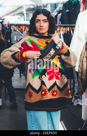 Una donna compra abbigliamento vintage e retrò in un mercato di Londra Foto Stock