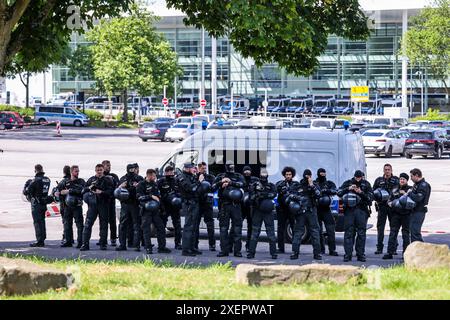 Essen, Germania. 29 giugno 2024. Gli agenti di un'unità BFE della polizia (unità di conservazione e arresto delle prove) si sono posizionati all'ombra sotto un albero a temperature elevate non lontano da Grugahalle, dove si svolge la conferenza nazionale del partito AfD. Alla conferenza di due giorni, l'AfD prevede di eleggere un nuovo comitato esecutivo federale, tra le altre cose. Numerose organizzazioni hanno manifestato opposizione alla riunione e più di una dozzina di contro-dimostrazioni. Credito: dpa/Alamy Live News Foto Stock