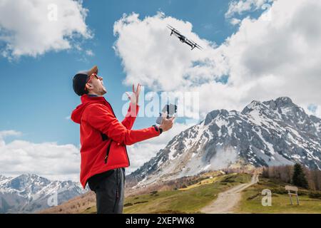 Con un'espressione folle, una persona lotta per riprendere il controllo del proprio drone volante dopo che un errore wireless porta a una pericolosa collisione. Foto Stock