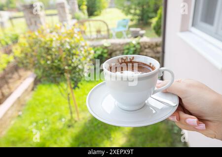 Caffè appena preparato in una tazza, tenuto in giardino Foto Stock