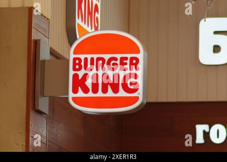 Tyumen, Russia - 20 giugno 2024: Burger King Side. Il segnale è fissato a una staffa metallica ed è visibile in un ambiente luminoso. Foto Stock