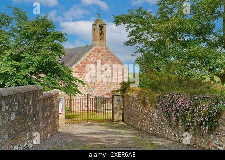 Kinneff Old Kirk o Church Aberdeenshire Scozia cancelli di ferro ingresso principale e fiori di clematide rosa che crescono sul muro Foto Stock