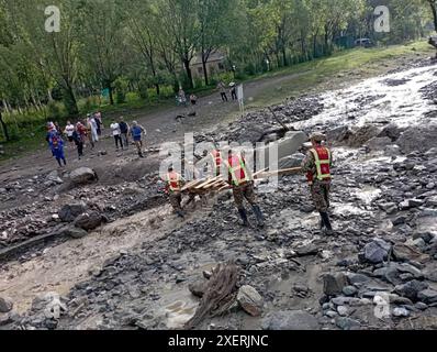 Bishkek, Kirghizistan. 28 giugno 2024. I soccorritori lavorano nel sito di un flusso di fango nella regione di Nookat, Osh Oblast, Kirghizistan, 28 giugno 2024. Cinque persone sono morte a causa di un flusso di fango nel sud del Kirghizistan, il servizio stampa del Ministero delle situazioni di emergenza del paese ha riferito sabato. Le forti piogge nella regione Nookat dell'Oblast' di Osh il venerdì hanno innescato flussi di fango, danneggiando due ponti, pali elettrici e inondando 15 cortili di case private. Crediti: Roman Gainanov/Xinhua/Alamy Live News Foto Stock