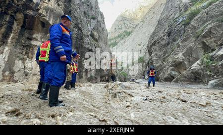 Bishkek, Kirghizistan. 28 giugno 2024. I soccorritori lavorano nel sito di un flusso di fango nella regione di Nookat, Osh Oblast, Kirghizistan, 28 giugno 2024. Cinque persone sono morte a causa di un flusso di fango nel sud del Kirghizistan, il servizio stampa del Ministero delle situazioni di emergenza del paese ha riferito sabato. Le forti piogge nella regione Nookat dell'Oblast' di Osh il venerdì hanno innescato flussi di fango, danneggiando due ponti, pali elettrici e inondando 15 cortili di case private. Crediti: Roman Gainanov/Xinhua/Alamy Live News Foto Stock