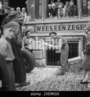 1945 Paesi Bassi, seconda guerra mondiale, forniture alimentari del Principe Bernardo che forniscono aiuti alle case dei bambini, con consegna del pane ai bambini affamati. Foto Stock