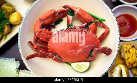 Un piatto vietnamita di granchio cotto guarnito con fette di lime ed erbe fresche, servito in una ciotola. Questo piatto popolare è un punto fermo della cucina vietnamita, kn Foto Stock
