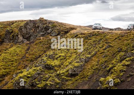 Auto fuoristrada parcheggiata ai margini della scogliera vulcanica ricoperta di muschio nel canyon di Gjain, valle di Þjórsárdalur, Islanda meridionale. Foto Stock