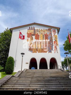 Schwyz, Svizzera - 18 giugno 2024: Edificio storico del Museo federale della carta con murale e bandiera svizzera. Foto Stock