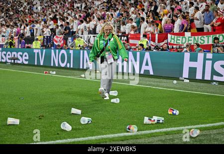 Dortmund, Germania. 30 giugno 2024. Calcio, UEFA Euro 2024, Campionato europeo, Germania - Danimarca, finale, round di 16, stadio di Dortmund, Una hostess calcia una tazza di birra fuori dal campo. Crediti: Bernd Thissen/dpa/Alamy Live News Foto Stock