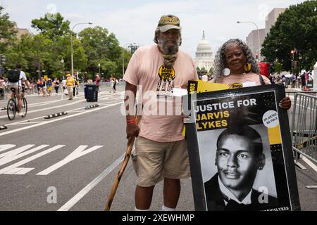 Washington DC, Stati Uniti. 29 giugno 2024. Due manifestanti stanno tenendo un cartello con le parole "giustizia per Jarvis Lykes" tra gli altri testi informativi durante la marcia dei poveri sulla Pennsylvania Ave a Washington DC, USA, il 29 giugno 2024. Jarvis Lykes, 35 anni, è morto per una ferita da arma da fuoco a seguito di un incontro con la pattuglia statale della Georgia nel dicembre 2017. Crediti: Aashish Kiphayet/Alamy Live News Foto Stock