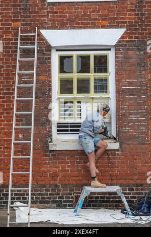 England, Kent, Sandwich, Female Builder at Work Restoring Historical Building Foto Stock