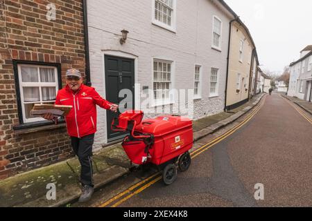 Inghilterra, Kent, Sandwich, Royal mail Postman che consegna la posta Foto Stock