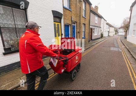 Inghilterra, Kent, Sandwich, Royal mail Postman che consegna la posta Foto Stock