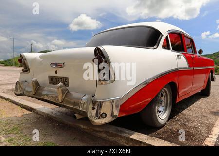 441 Vista posteriore e laterale, auto d'epoca americana rossa dal tetto bianco - Chevrolet del 1956 - di stanza a El Cobre-Basilica nostra Signora della Carità. Santiago-Cuba. Foto Stock