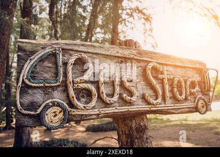 Una fermata dell'autobus con cartelli in legno fatta di lettere di corda Foto Stock