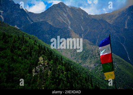 L'immagine mostra la bellezza dell'Himalaya a Chitkul, in India, con la bandiera buddista in primo piano e le montagne innevate sul retro. Foto Stock