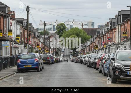 Selly Oak, Birmingham, 30 giugno 2024 - file di Terrace Street conducono all'Università di Birmingham e al Queen Elizabeth Hospital (il QE è l'edificio bianco in lontananza). - Le strade residenziali di Birmingham sono state trasformate in discarica mentre gli studenti si spostano di casa alla fine dei loro contratti. La maggior parte degli studenti frequenta l'Università di Birmingham, che si trova a circa 800 metri dalle strade abitative terrazzate di Selly Oak. Le strade sono state acquistate principalmente da proprietari terrieri che le affittano ai laureandi con una fila di insegne "in affitto". Credito: Interrompi stampa Media/Alamy Live Foto Stock