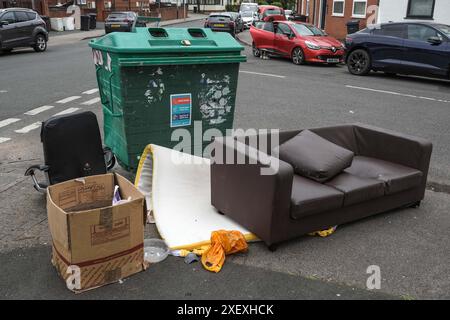 Selly Oak, Birmingham, 30 giugno 2024 - anche Un divano è stato scaricato in strada. - Le strade residenziali di Birmingham sono state trasformate in discarica mentre gli studenti si spostano di casa alla fine dei loro contratti. La maggior parte degli studenti frequenta l'Università di Birmingham, che si trova a circa 800 metri dalle strade abitative terrazzate di Selly Oak. Le strade sono state acquistate principalmente da proprietari terrieri che le affittano ai laureandi con una fila di insegne "in affitto". Anche alcuni residenti locali vivono nella zona, tra i giovani speranzosi e hanno soprannominato la zona "Smelly Oak". Credito: Sto Foto Stock