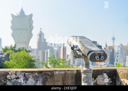 Osservatore della torre presso la piattaforma di osservazione di Macao. Binocolo a gettoni situato in una popolare destinazione turistica dell'Asia. Foto Stock