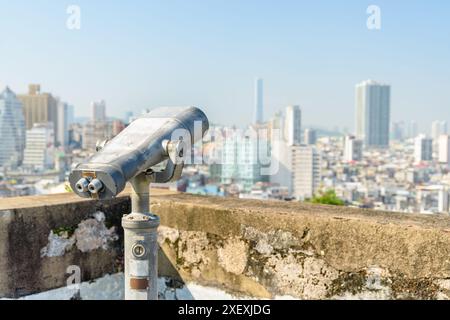 Osservatore della torre presso la piattaforma di osservazione di Macao. Binocolo a gettoni situato in una popolare destinazione turistica dell'Asia. Foto Stock