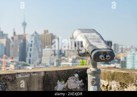 Osservatore della torre presso la piattaforma di osservazione di Macao. Binocolo a gettoni situato in una popolare destinazione turistica dell'Asia. Foto Stock