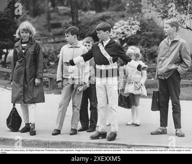 Junior Safety Patrol negli anni '1960 Un ragazzo adolescente sta in piedi con le braccia aperte e segnala ai pedoni di fermarsi al trampolino. Quando le auto sono passate o si sono fermate, i bambini possono attraversare la strada. Far parte della pattuglia di sicurezza Junior era volontario per gli studenti della scuola e la ricompensa a volte era quella di fare viaggi ed escursioni più brevi. Oggi, l'operazione è chiusa in molti comuni. Svezia 1964 Foto Stock