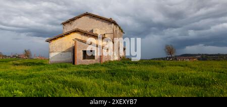 Vecchia casa colonica con potenziale ristrutturazione su una collina verde Foto Stock