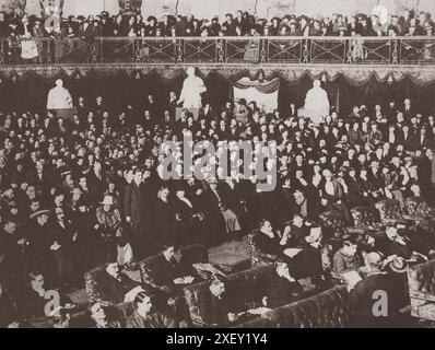 "Parlamento" irlandese in sessione a Mansion House, Dublino, Irlanda. 27 febbraio 1919 sessione di apertura storica dell'Assemblea Costituente irlandese, membri del Sien Fein che occupano sedie imbottite di fronte. Dietro, e in galleria, ci sono spettatori composti in gran parte da donne, sacerdoti e studenti. Foto Stock