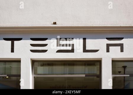 Heidelberg, Germania - 28 giugno 2024: Logo del marchio di auto elettriche Tesla sopra il negozio dello showroom nel centro della città Foto Stock