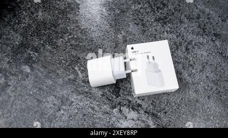 Jurmala, Lettonia 22.06.2024: Scatola bianca dell'adattatore di ricarica originale da 20 W di Apple su un tavolo grigio. Foto Stock