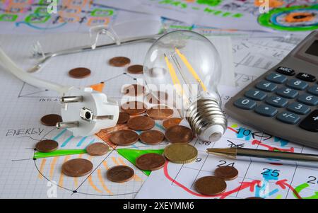 Concetto aziendale: Pianificazione dei costi energetici nel budget mensile. STILL Life con calcolatrice, lampadina, spina e diagrammi Foto Stock