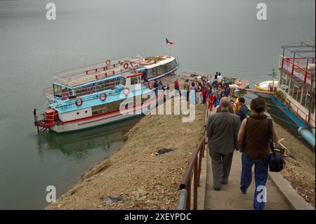 I turisti si imbarcano su barche da diporto sul lago Vidraru in Romania Foto Stock