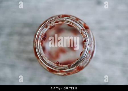 Glasgefäß, leeres Marmeladenglas, leergegessen, Leere, von oben, kreative Unschärfe Wertstoff Glas *** vaso di vetro, vaso di marmellata vuoto, vaso vuoto, dall'alto, vetro riciclabile sfocato Foto Stock