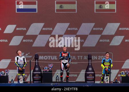 ASSEN - Collin Veijer (NED) (secondo) guarda le bandiere accanto al vincitore Ivan Ortola (ESP) (m) e David Munoz (ESP) (terzo) (r) durante l'onore della gara Moto3 dell'Assen TT 2024. ANP VINCENT JANNINK Foto Stock