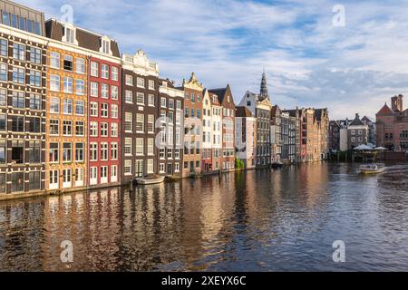 Scenario di Damrak ad Amsterdam, olandese. Le case si trovano direttamente sull'acqua Foto Stock