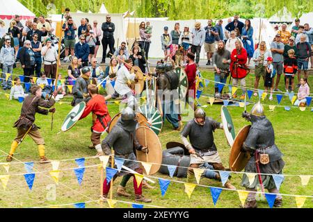 Finta battaglia con due gruppi di cavalieri che combattevano tra loro in un'area delimitata sul green a Sandwich durante un evento di rievocazione medievale. Foto Stock