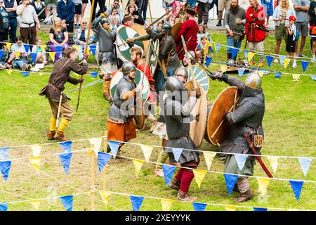 Finta battaglia con due gruppi di cavalieri che combattevano tra loro in un'area delimitata sul green a Sandwich durante un evento di rievocazione medievale. Foto Stock